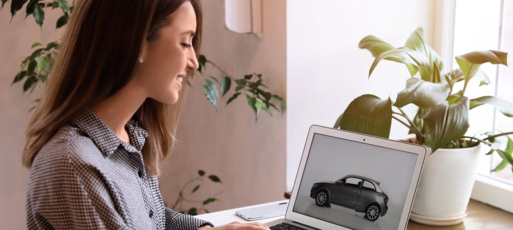 woman looking at a car on a laptop