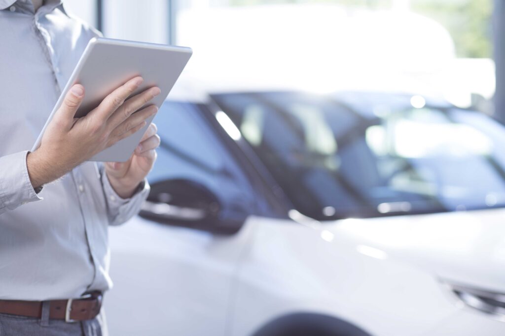 Male hands holding a notepad, cars in background