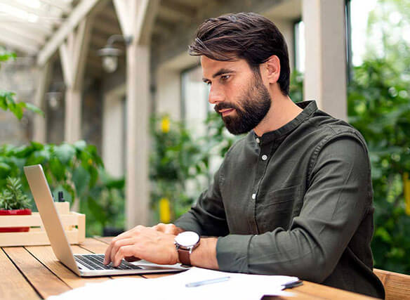 Man sitting outside working on a laptop