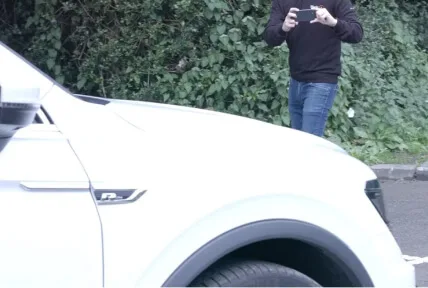 Man taking a picture of a car